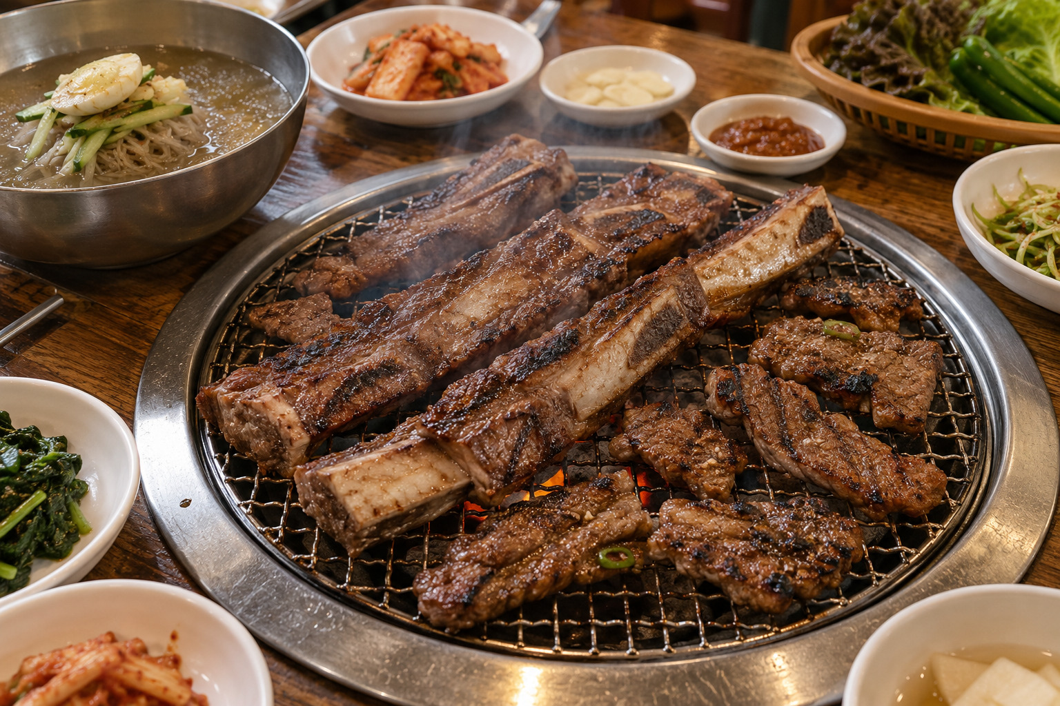 원형 숯불 불판에서 익고 있는 수원식 왕갈비와 양념갈비